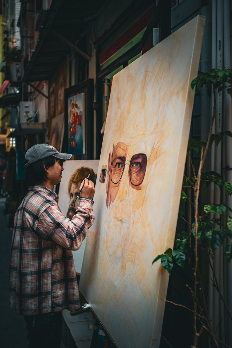 Artist painting a portrait in Dafen alley